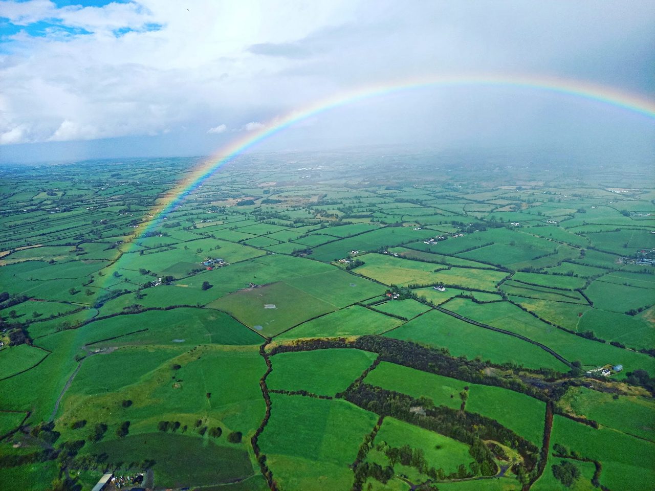 Vista aérea dos campos verdes de Athenry, com um arco-íris sobre a paisagem