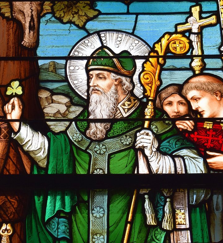 Vitral de São Patrício com vestes verdes, báculo e um trevo na mão
